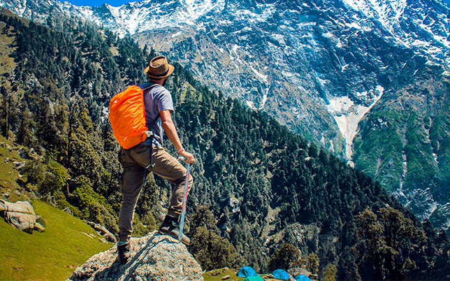home-hero Wanderer mit Rucksack auf einem Bergpfad in der Natur.